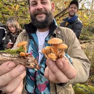 A wild food walk participant showing off mushrooms collected during a wild food walk