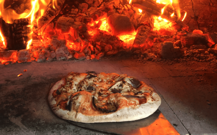 Foraged ingredient pizza being put into fire